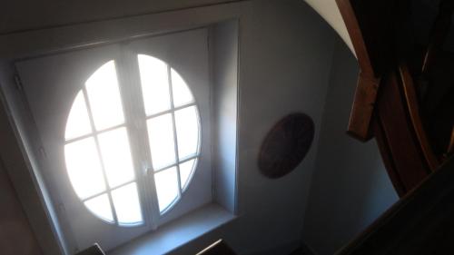 a round window in a room with a staircase at Le Compostelle Chic, Charme, Confort, Cocooning 80 m² in Saint-Léonard-de-Noblat