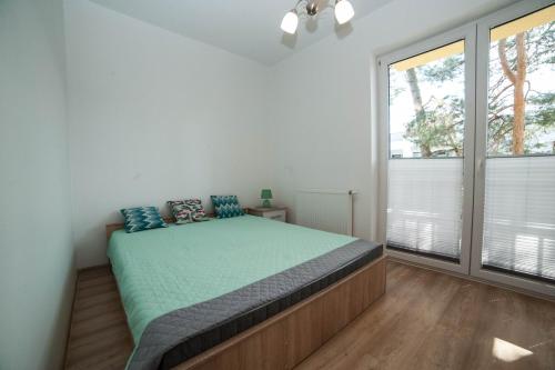 Un dormitorio con una cama con almohadas azules. en Apartamenty Magnat en Pogorzelica