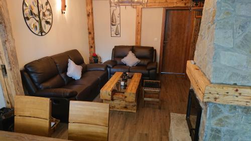 a living room with a leather couch and a coffee table at Plitvički San in Korenica