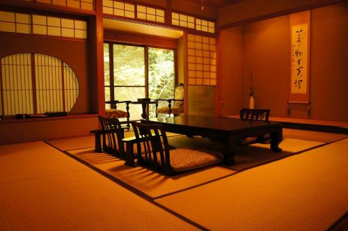 um quarto com uma mesa e cadeiras e uma janela em Warabino em Yufu