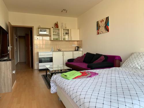 een slaapkamer met een bed en een paarse bank bij Apartment Fiala in Olomouc