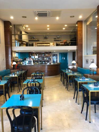 un restaurante con mesas y sillas y un bar en Hotel Celimar, en Sitges