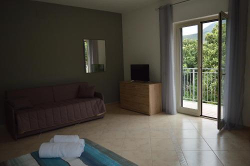 Vista D'amare في Buonvicino: غرفة معيشة مع أريكة وباب زجاجي منزلق