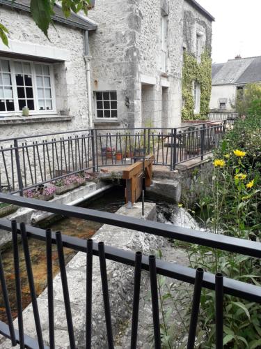 a house with a bridge in front of a yard at Moulin Béchereau in Mer