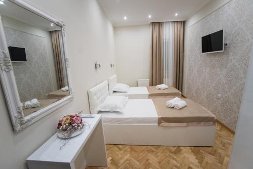 ein Hotelzimmer mit einem Bett und einem Spiegel in der Unterkunft Center Deluxe Garni Hotel in Niš