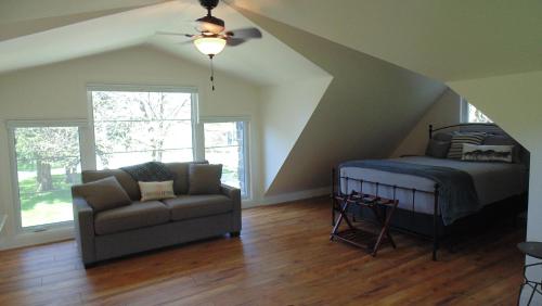 a attic bedroom with a bed and a couch at Carriage House On Kent in Niagara on the Lake