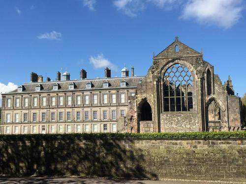 エディンバラにあるNext Door to Holyrood Palace and Arthur's Seatの大きな窓のある大きな石造りの建物