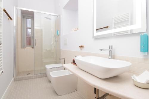 a white bathroom with a sink and a toilet at Dimora Cummà Marì in Vieste