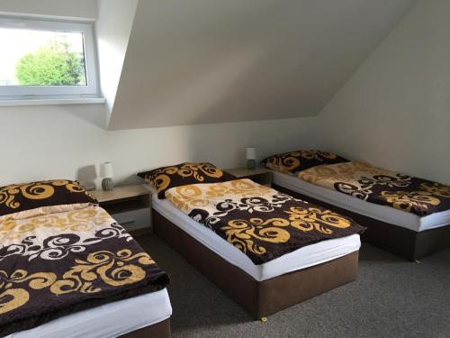three beds in a room with a window at Rychlebská bašta in Černá Voda