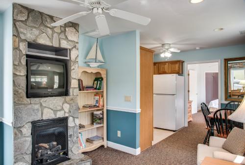 a living room with a stone fireplace and a tv at Boxwood Lodge Blowing Rock near Boone-University in Blowing Rock
