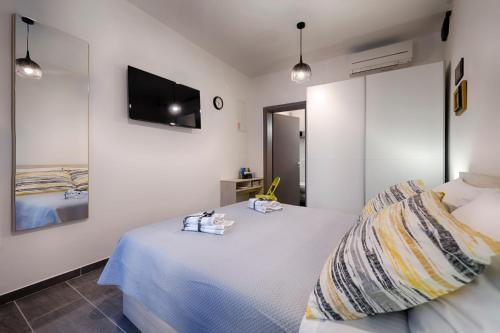 a bedroom with a bed and a tv on the wall at En Suite Room Demaria in Komiža