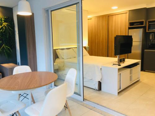 Habitación con cama, mesa y TV. en Premium Baixo Augusta, en São Paulo