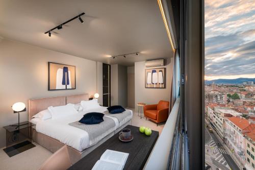 a bedroom with a bed and a view of a city at Royal Suites-Sky in Split