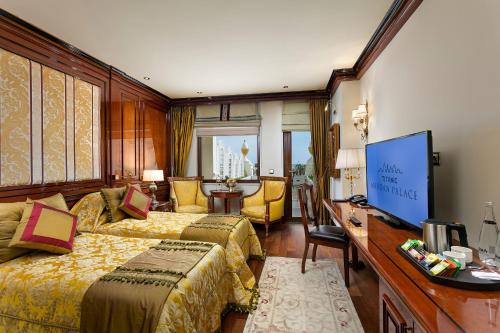 a hotel room with two beds and a desk at Titanic Mardan Palace in Lara