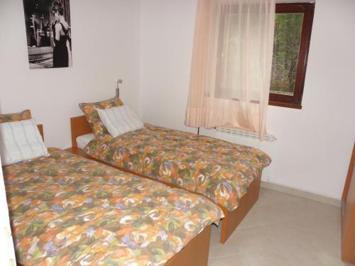 a bedroom with two beds and a window at Apartments Ruzica - 50 m from sea in Jezera