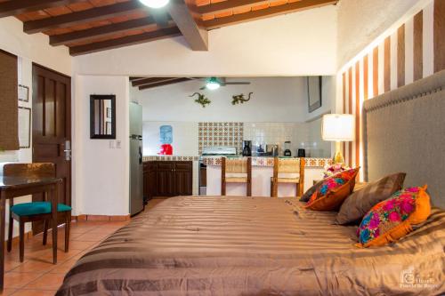 a bedroom with a large bed and a kitchen at Hotel Posada De Roger in Puerto Vallarta