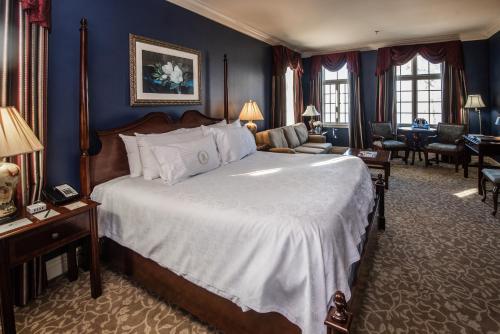 a bedroom with a large bed and a living room at River Inn of Harbor Town in Memphis