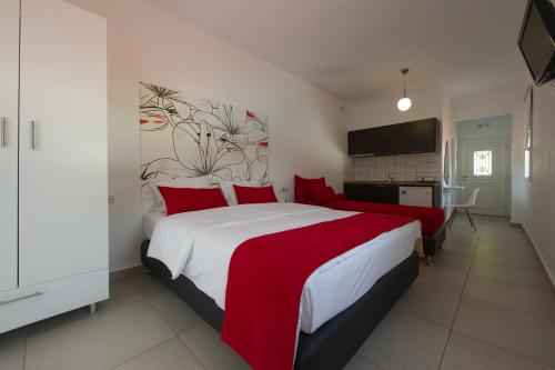 a bedroom with a large bed with red pillows at MARIS PARGA in Parga