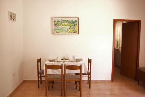 un comedor con una mesa con sillas y una foto en la pared en Romantic Apartment In Nature, en Borovići