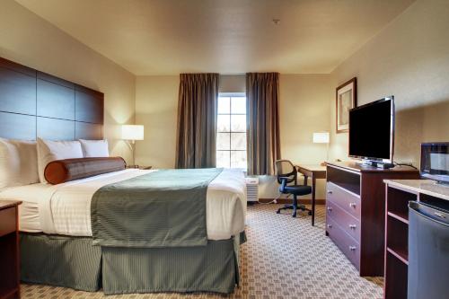 Cobblestone Hotel & Suites - Charlestown في Charlestown: غرفة فندقية بسرير وتلفزيون بشاشة مسطحة