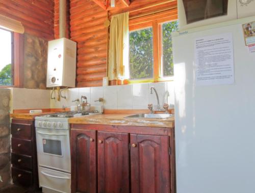 a kitchen with a sink and a stove at Rancho Escondido in Mina Clavero