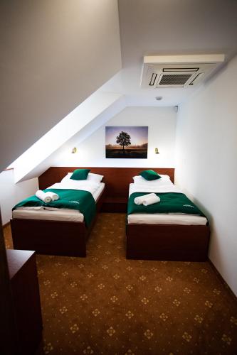 a bedroom with two beds in a room at Penzión Poľovník in Moldava nad Bodvou