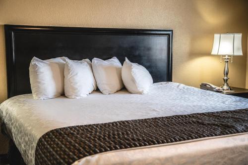 a hotel room with a bed with white pillows at The Stone Castle Hotel & Conference Center in Branson