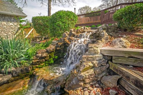 a waterfall in a backyard with a stone wall at The Stone Castle Hotel & Conference Center in Branson
