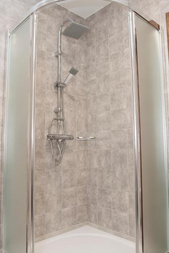 a shower with a shower head in a bathroom at Penzión Poľovník in Moldava nad Bodvou