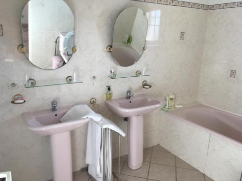 y baño con 2 lavabos, bañera y espejo. en Le paradis de la Provence, en Verenay