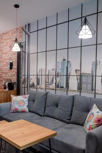 a living room with a couch and a large window at Apartamenty Czestochowa Eu "parking gratis" in Częstochowa