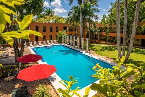 ein Pool mit Sonnenschirmen und ein Resort in der Unterkunft Hacienda Uxmal Plantation & Museum in Uxmal