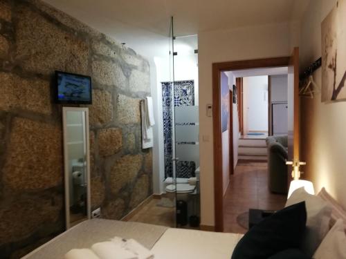 uma sala de estar com uma parede de pedra e um espelho em Casa São Dinis no Porto