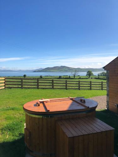 a hot tub sitting in the grass next to a fence at Oakwell holiday village in Ramelton