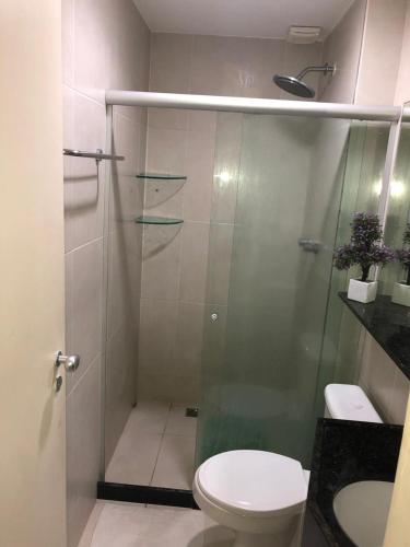 a bathroom with a toilet and a glass shower at Ancorar Flat Porto de Galinhas-Flat 3311-3314 in Porto De Galinhas