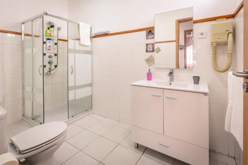biała łazienka z toaletą i prysznicem w obiekcie Rocky3 w mieście Angra do Heroísmo