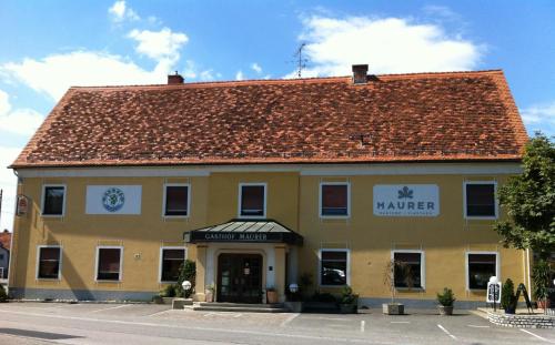 a large yellow building with a red roof at Maurer Gasthof-Vinothek in Gleisdorf