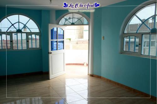un pasillo con paredes azules y una puerta blanca en Hospedaje La Ola Azul en Puerto Chicama
