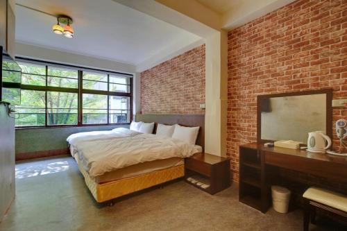 a bedroom with a bed and a brick wall at DC Hotel in Taichung