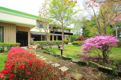 a garden in front of a building with pink flowers at Kounso in Yamanakako