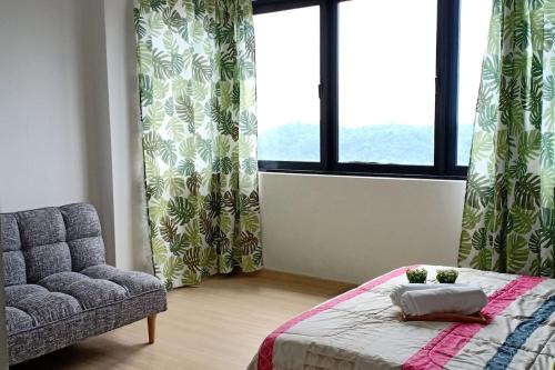 a bedroom with a bed and a chair and a window at Manee Home Kota Damansara in Kuala Selangor