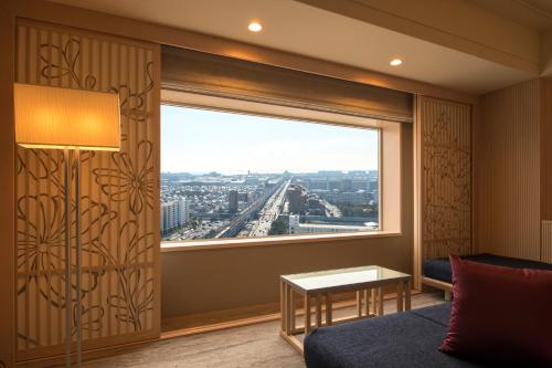 a room with a large window with a view of the city at Urayasu Brighton Hotel Tokyo Bay in Urayasu