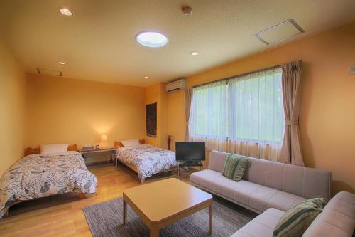 a living room with two beds and a couch at Kounso in Yamanakako