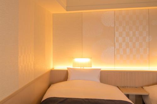 a bedroom with a bed with a lamp on it at Urayasu Brighton Hotel Tokyo Bay in Urayasu
