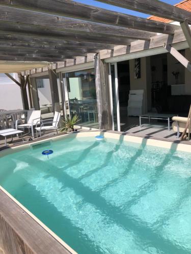 - une grande piscine sur une terrasse avec des chaises dans l'établissement SCI DES BAINES, à Vieux-Boucau-les-Bains