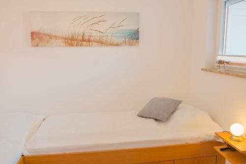 a bed in a bedroom with a picture on the wall at Haus am Deich Wohnung 4 in Dahme