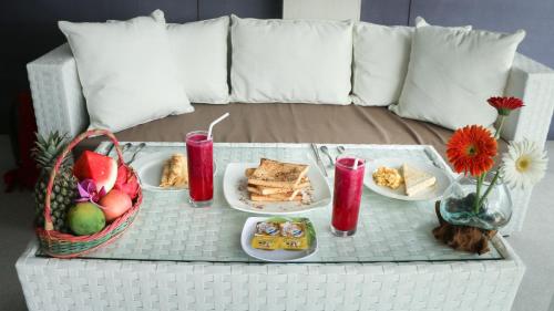 een tafel met een dienblad met eten op een bank bij Nick Villas by Villa Finder in Ubud