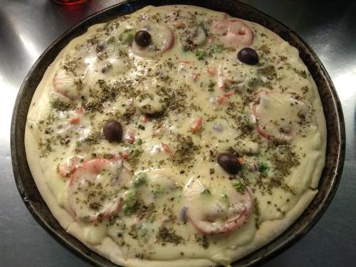 une pizza avec des crevettes et des olives dans un pan dans l'établissement Guest House Peter Flanders, à Tigre