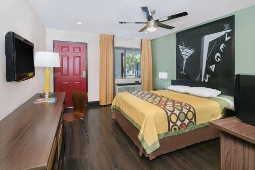 a bedroom with a bed and a desk and a tv at Super 8 by Wyndham Austin University/Downtown Area in Austin