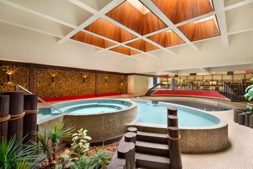 a large swimming pool in a building with a spa at Ramada Plaza by Wyndham Regina Downtown in Regina